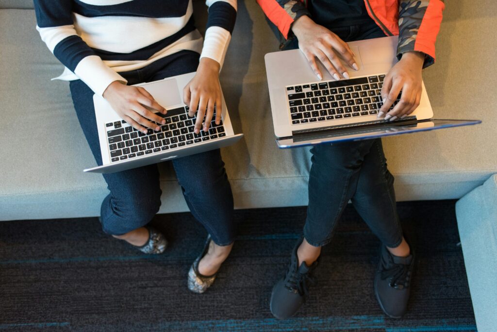 Two people working on laptops from above, showcasing collaboration in a tech environment. best notebooks for students Top 7 Best Laptops for Students on Amazon in 2025