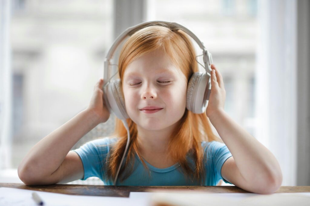 A young girl with headphones enjoying music indoors with a joyful expression. Top 7 Best Headphones on Amazon