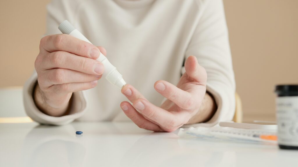 Close-up of a person using a glucometer to test blood sugar at home. Gluco6 Supplement